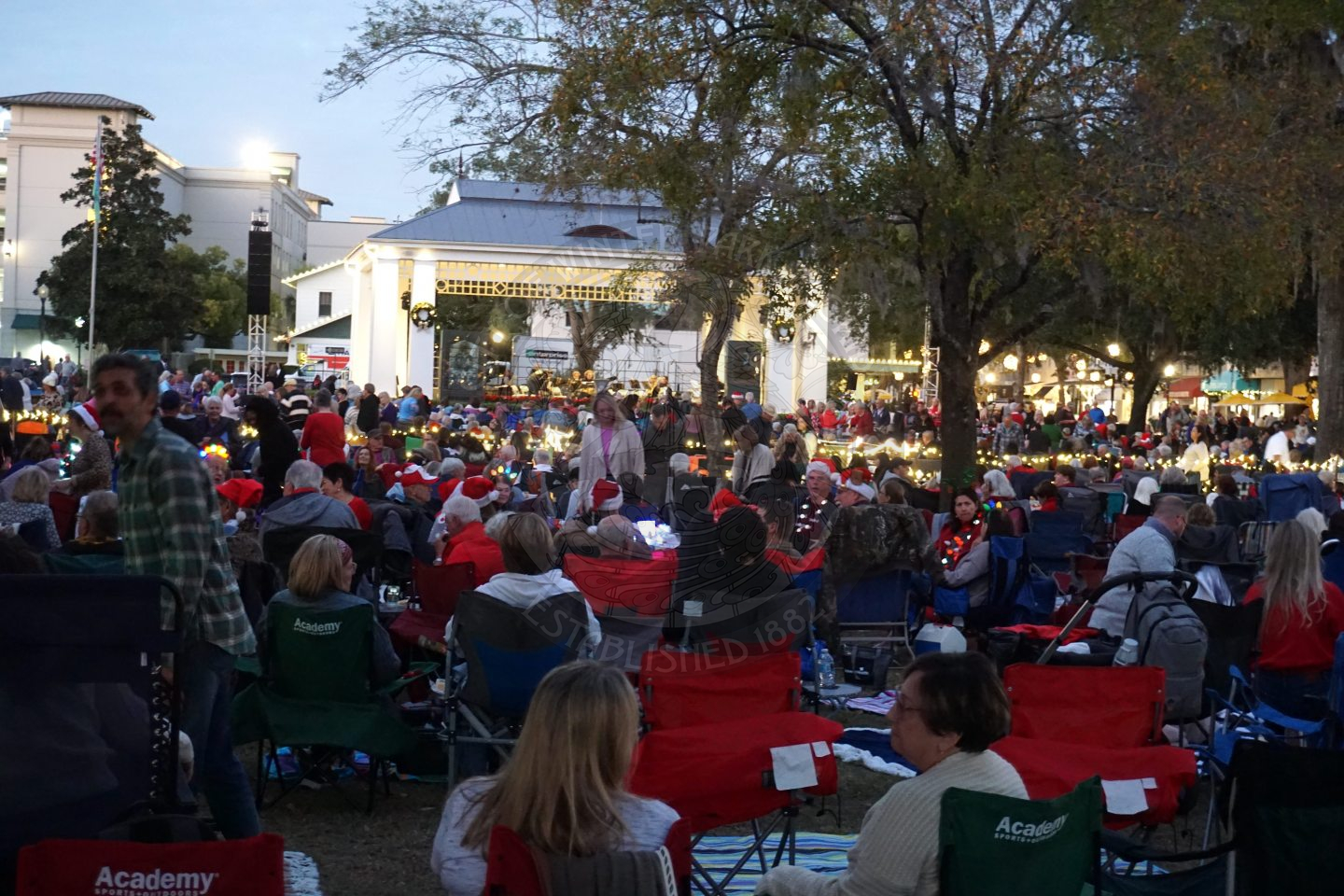 A crowd of people sitting down down watching a band perform a concert.