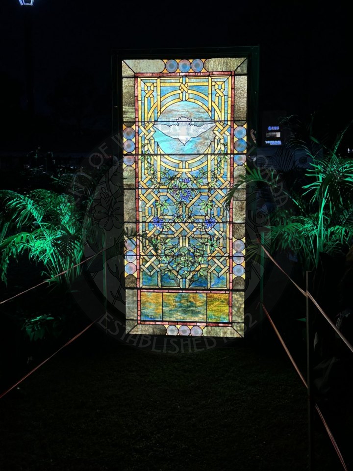 a tiffany stained glass window with two palm trees next to the painting.
