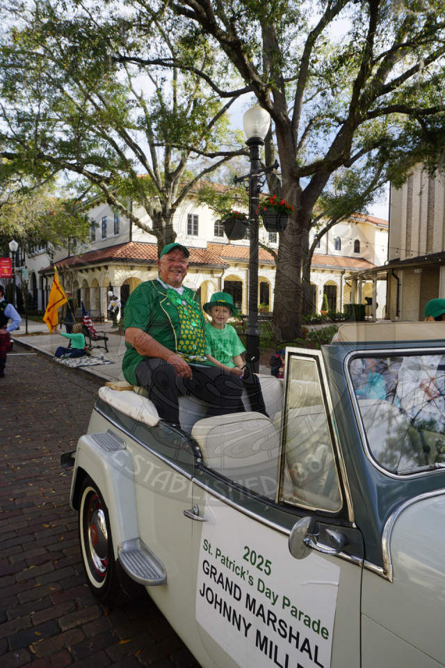an older man and young kid sitting on the back of a car 