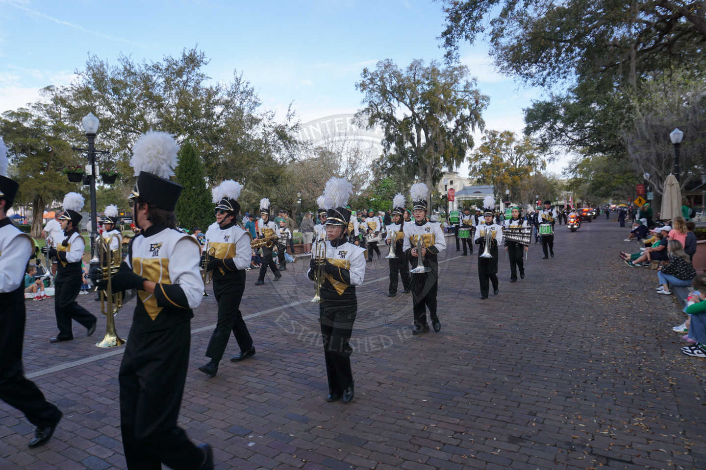 Bishop Moore High School band kids marching down a brick street.