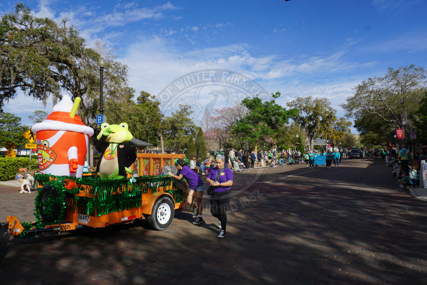 Jeremiah's Italian Ice frog mascot riding in a trailer
