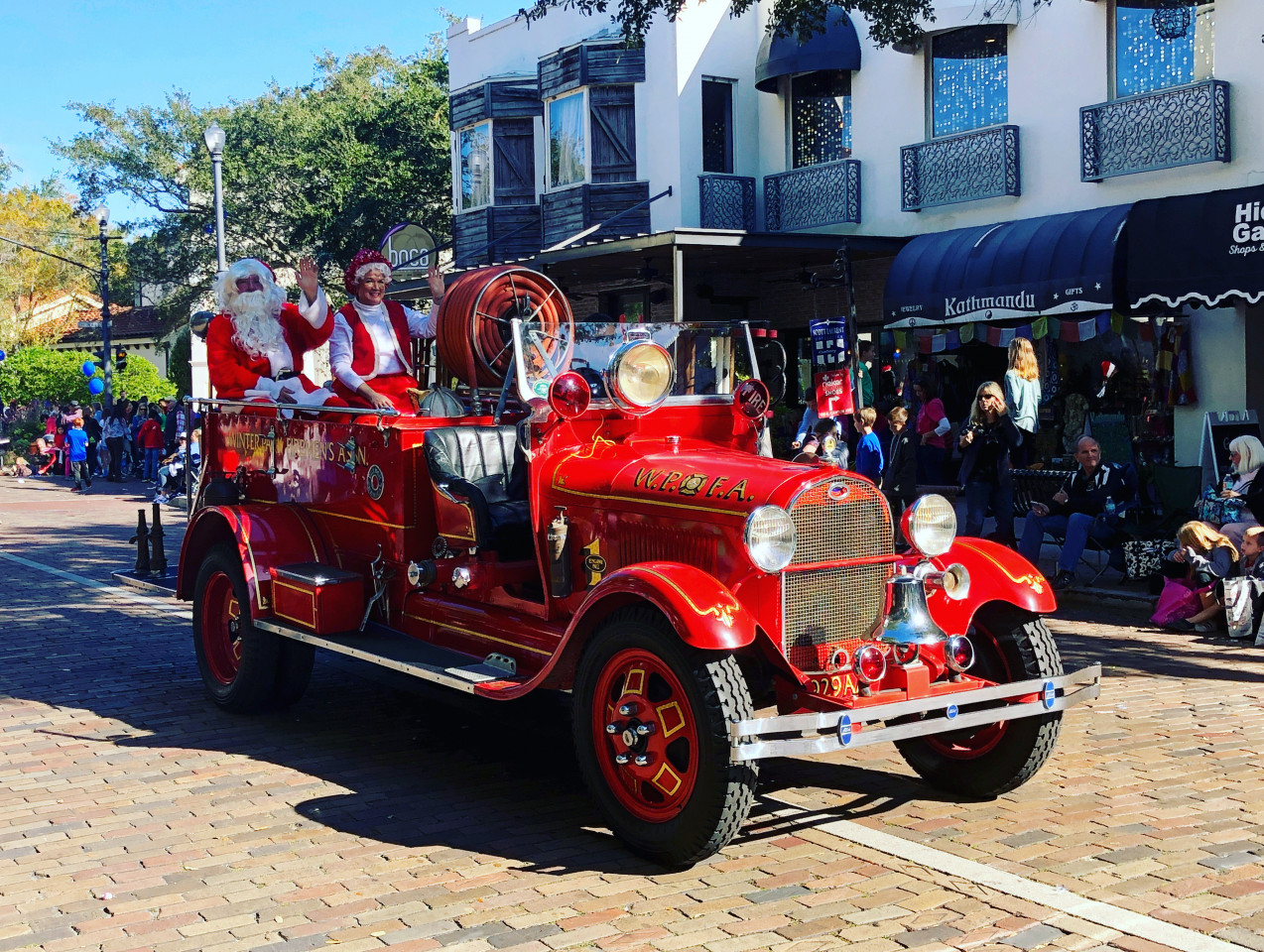 Santa and Mrs. Claus in an old school fire truck during the parade