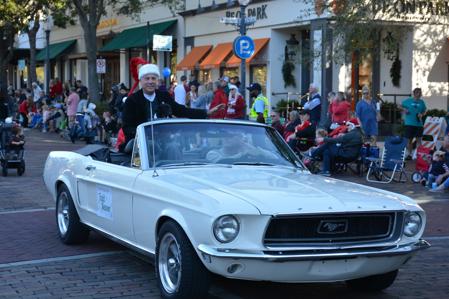 Commissioner Weaver and his dog waving in the back of a car during the parade