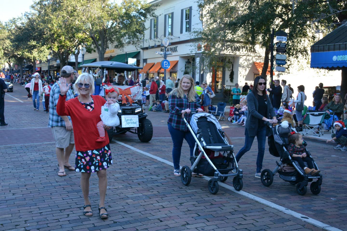 Commissioner Sprinkel holding her granddaughter and waving during the parade
