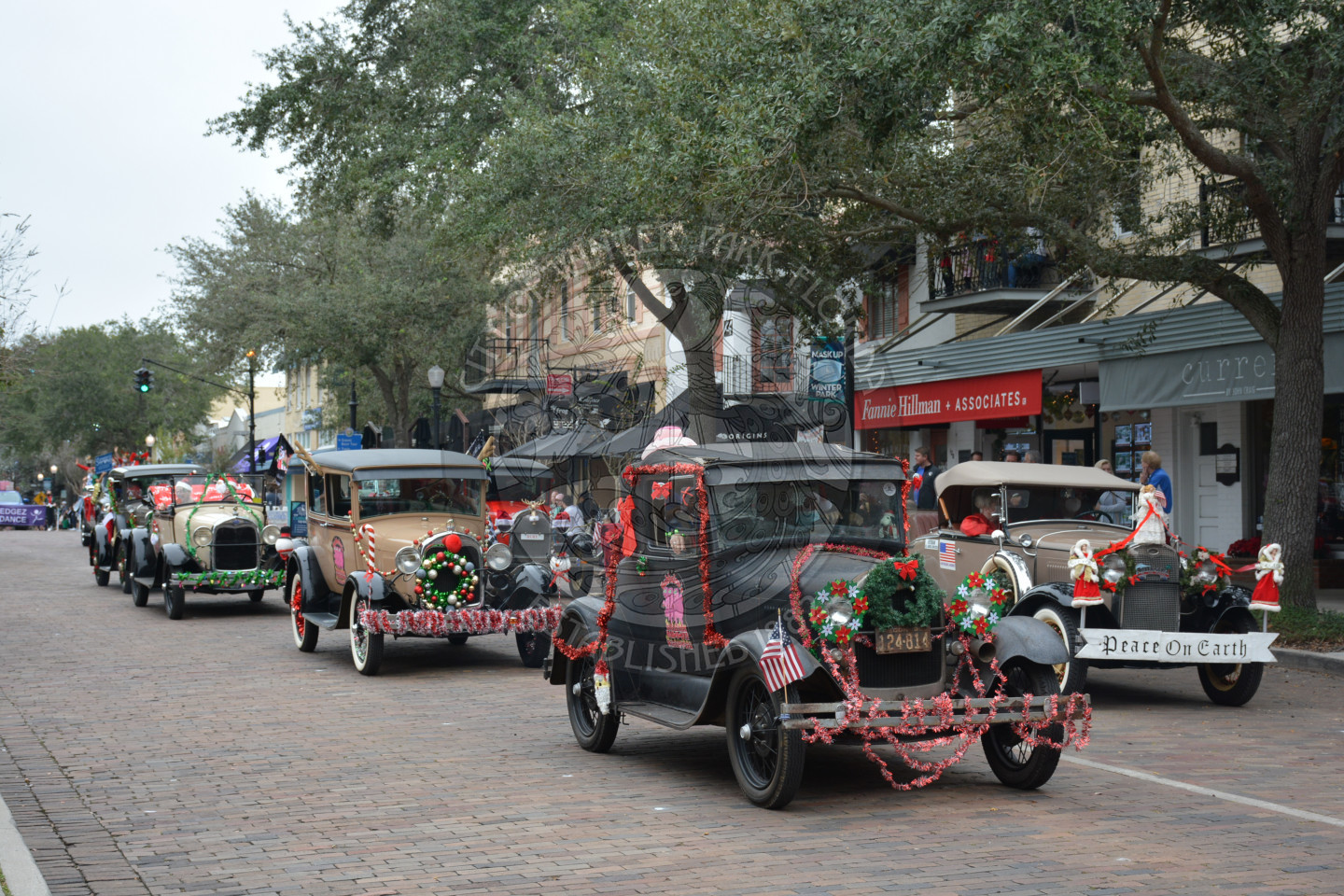 group of old fashioned cars coming down the parade route