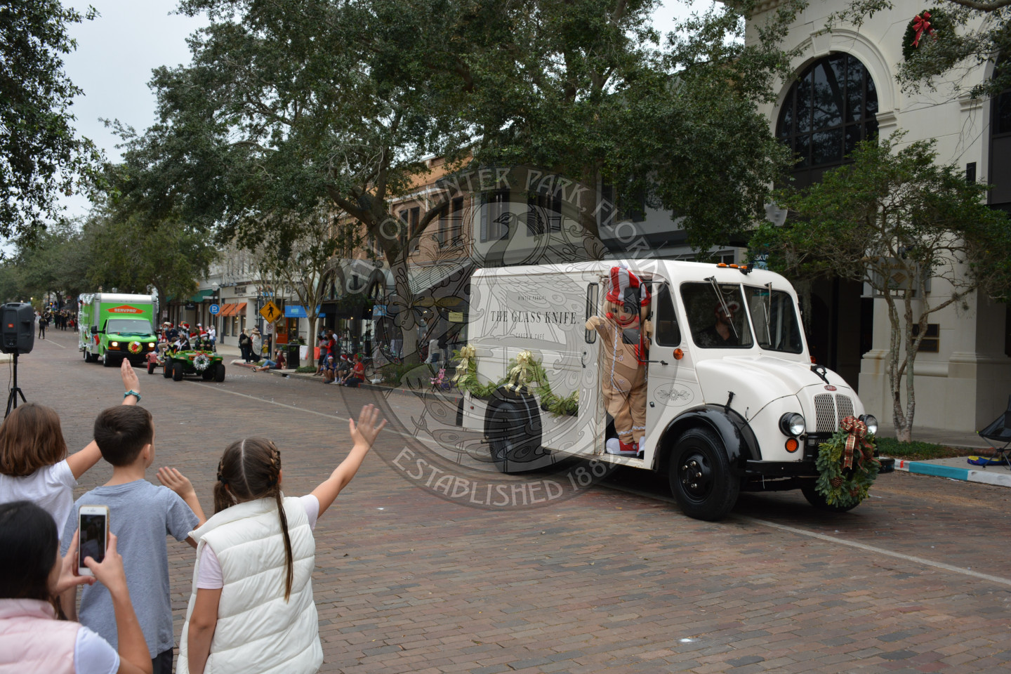 The Glass Knife gingerbread man waving to children at the parade