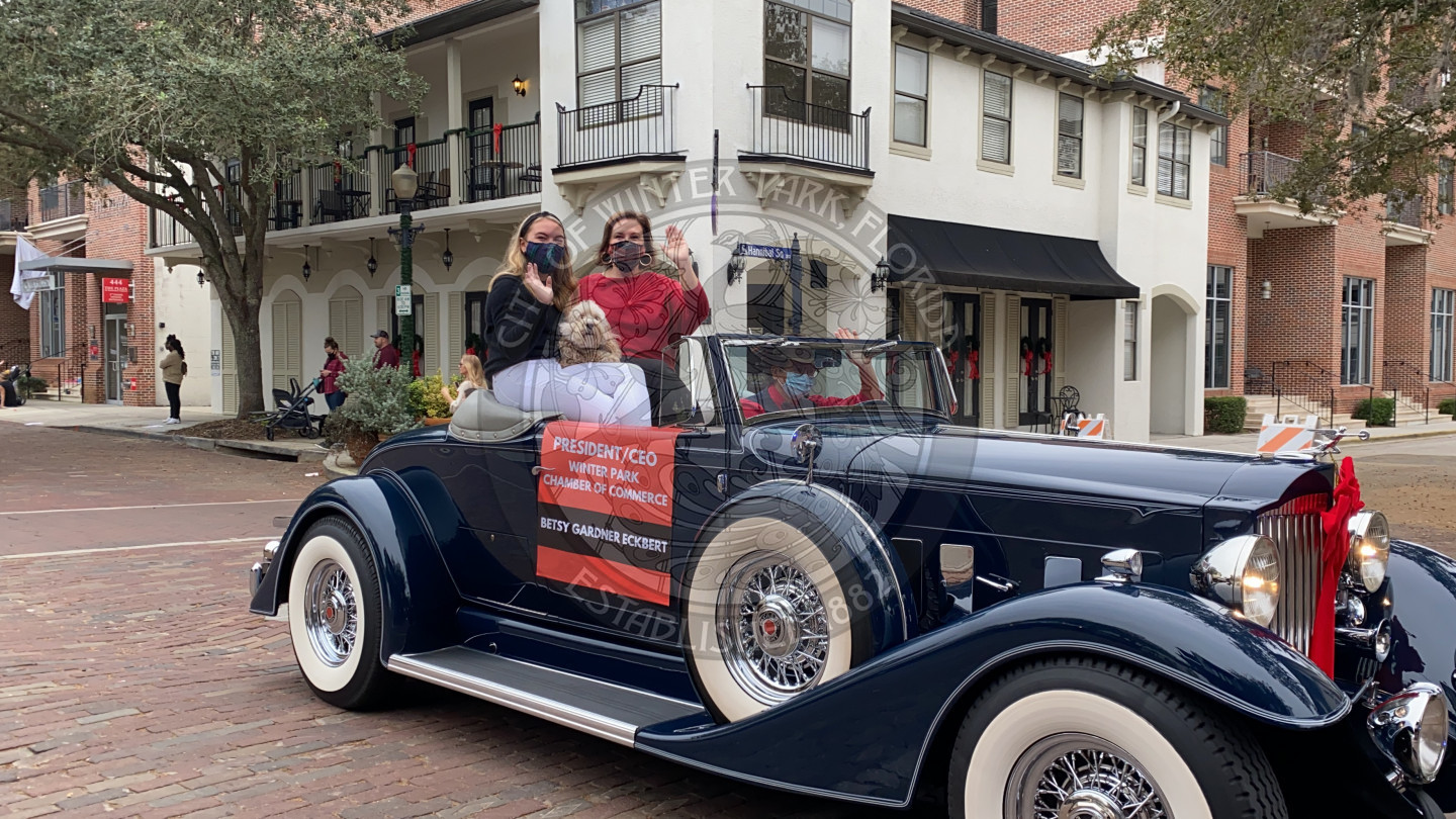 President of the Winter Park Chamber with her daughter and dog in their parade car