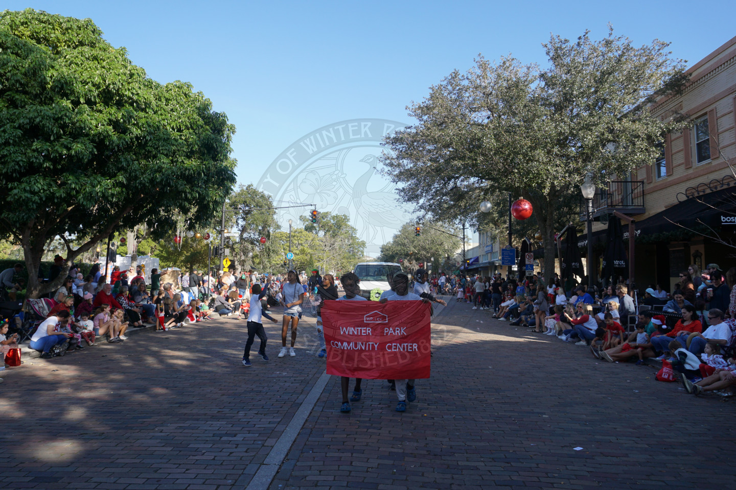 2 boys walking down Park Avenue holding the Winter Park Community Center