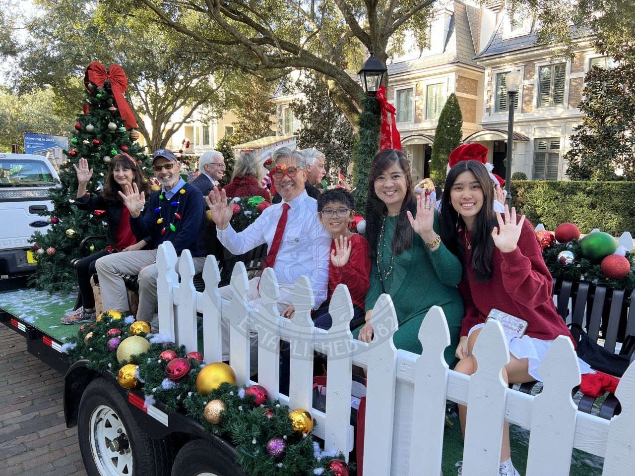 City Commission and family sitting down waving to people along Park Avenue.