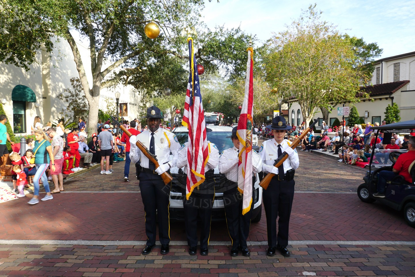Winter Park Police Department color gaurd standing in front of a police vehicle waiting  to start walking the parade.