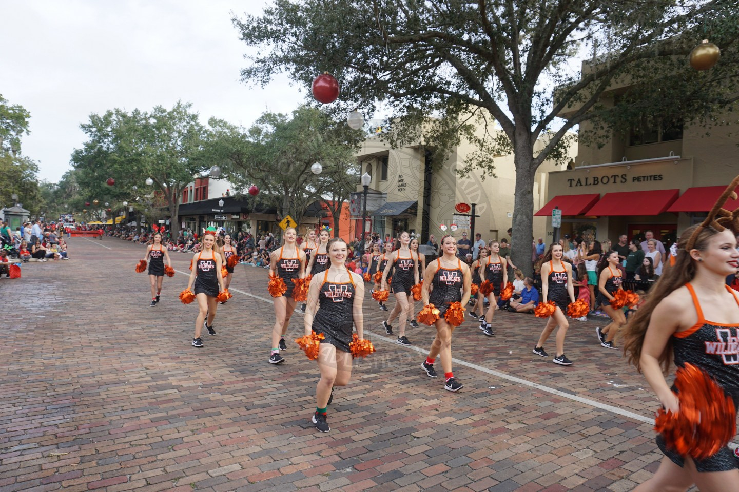 Winter Park High School cheerleaders lined up marching down Park Avenue cherring.