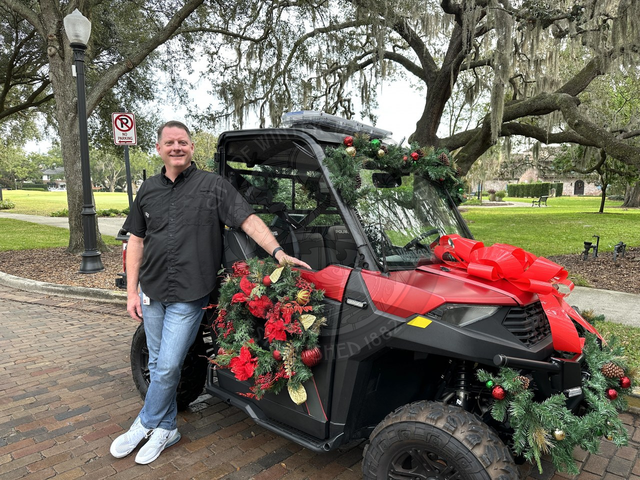 Fire Chief Dan Hagedorn standing and smiling next to a Christmas decorated ATV.