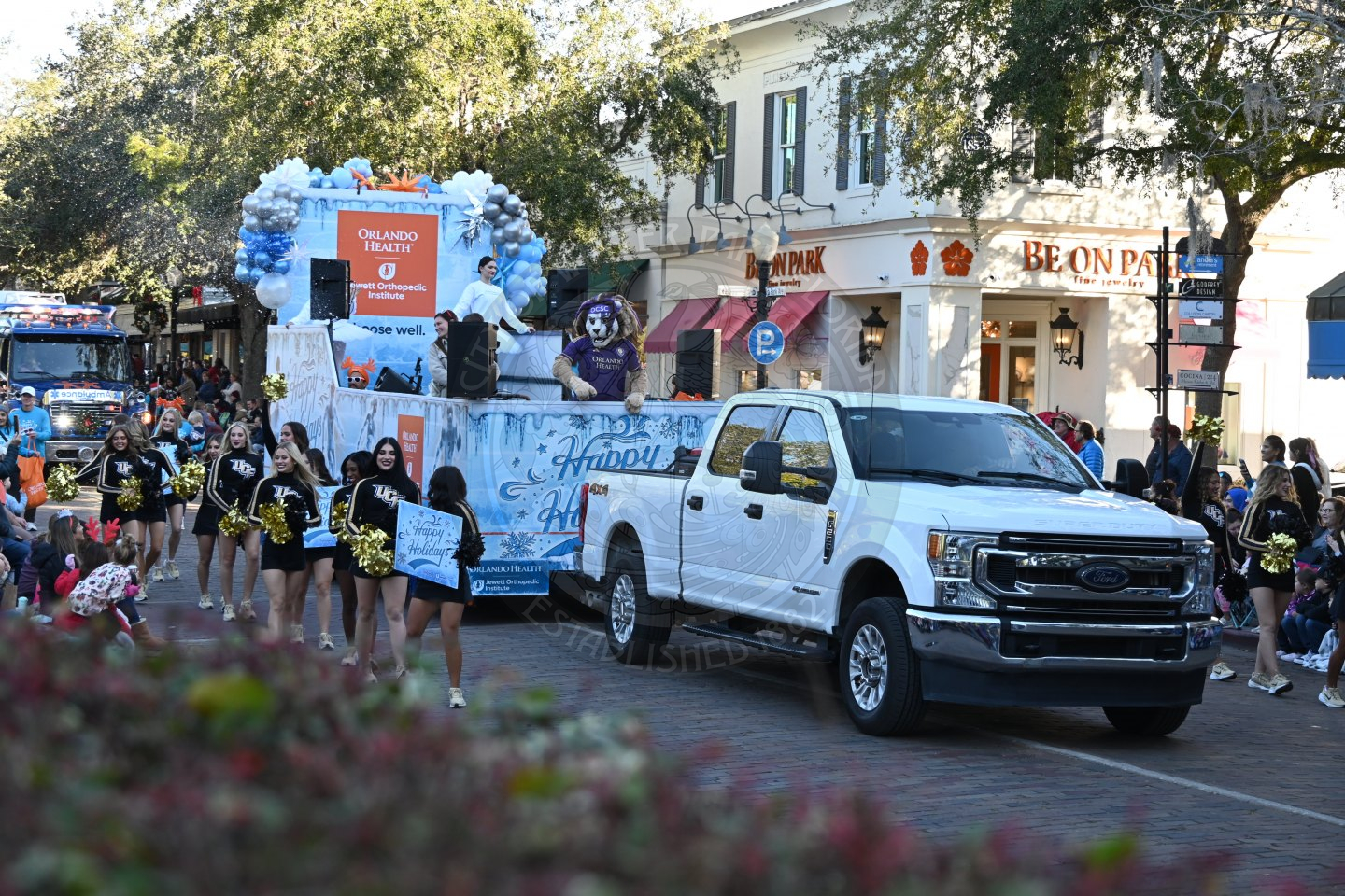 UCF cheerleaders and Orlando City Soccer mascot on the parade route.
