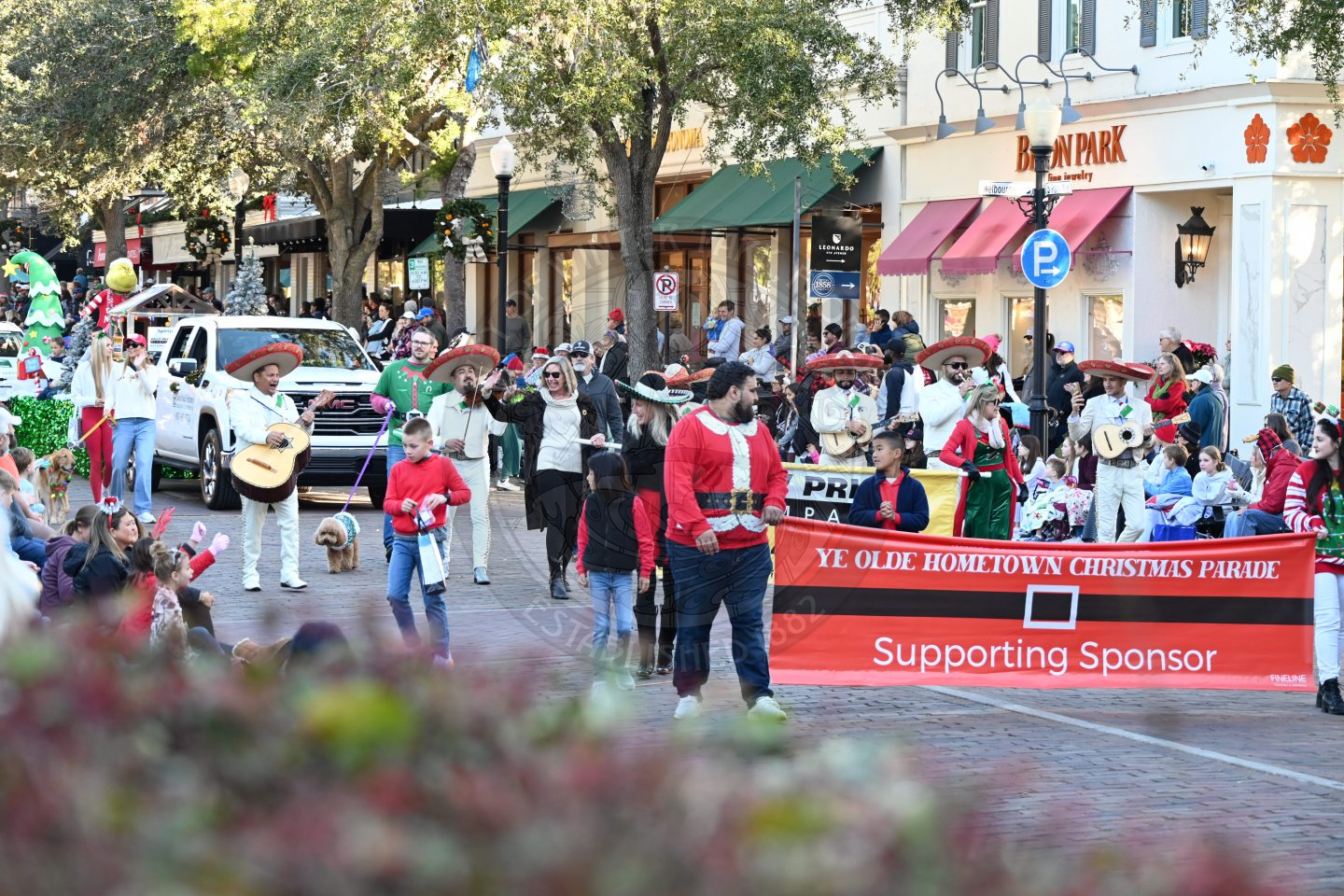 group of people walking down park avenue and waving at everyone sitting down watching.