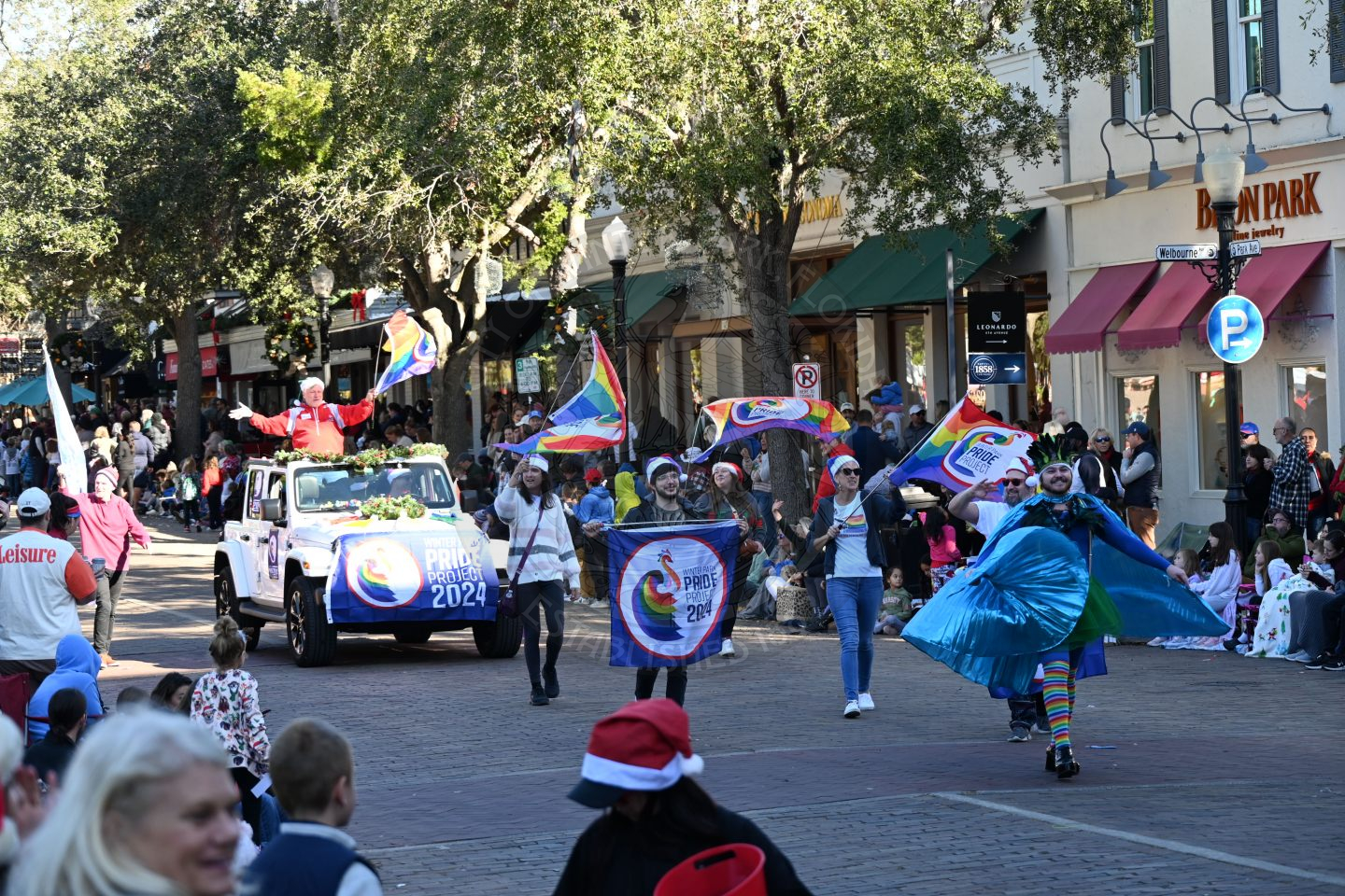 Orlando Pride Project walking down park avenue waving rainbow flags.