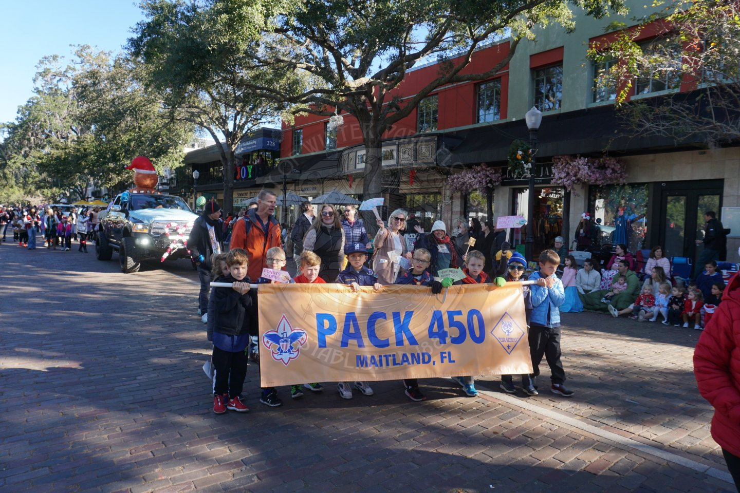 cub scouts holding a banner and wlaking down park avnue.