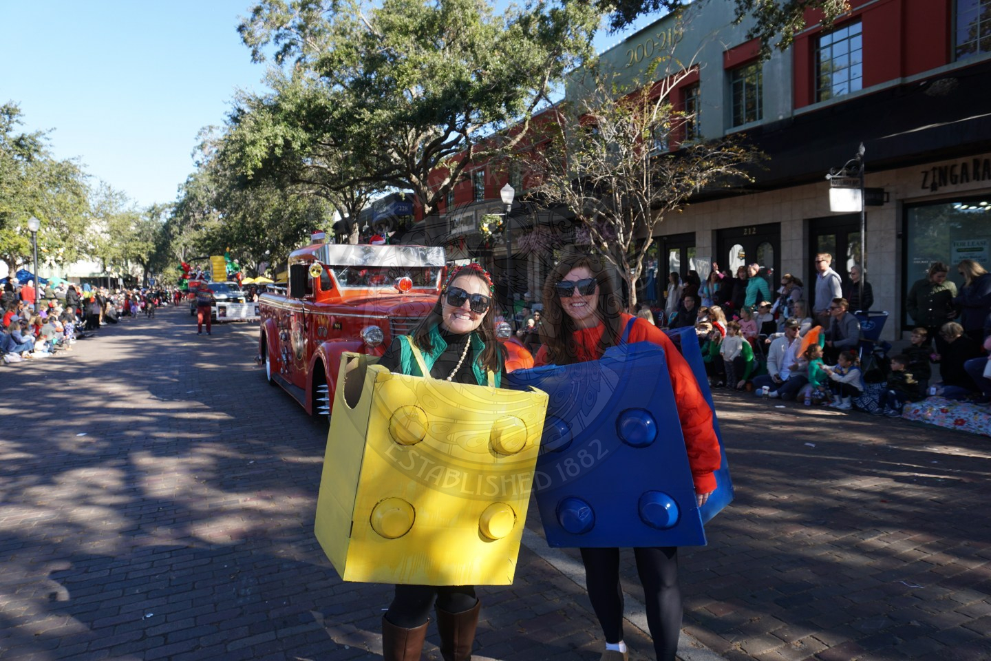 two women dressed as a lego and smiling.