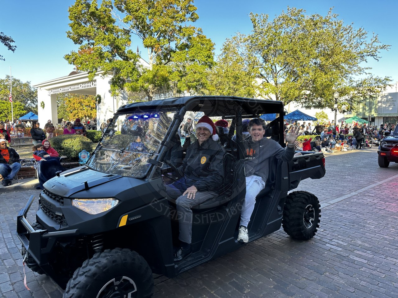 Cheif Volkerson driving a golf car with some kids in the back seat.