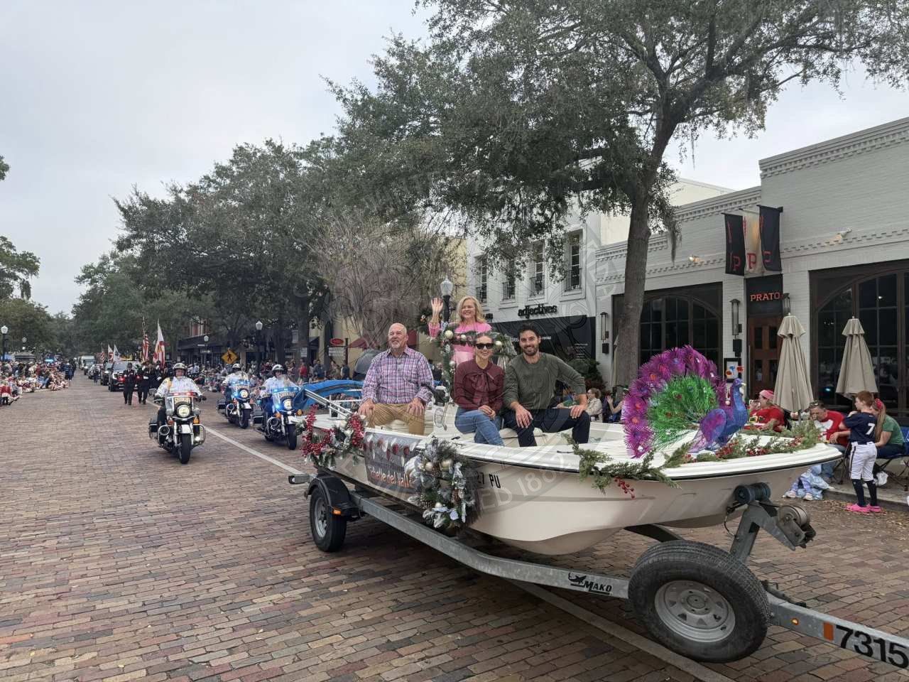 a group of people riding in a decorated boat on a trailer in a parade.