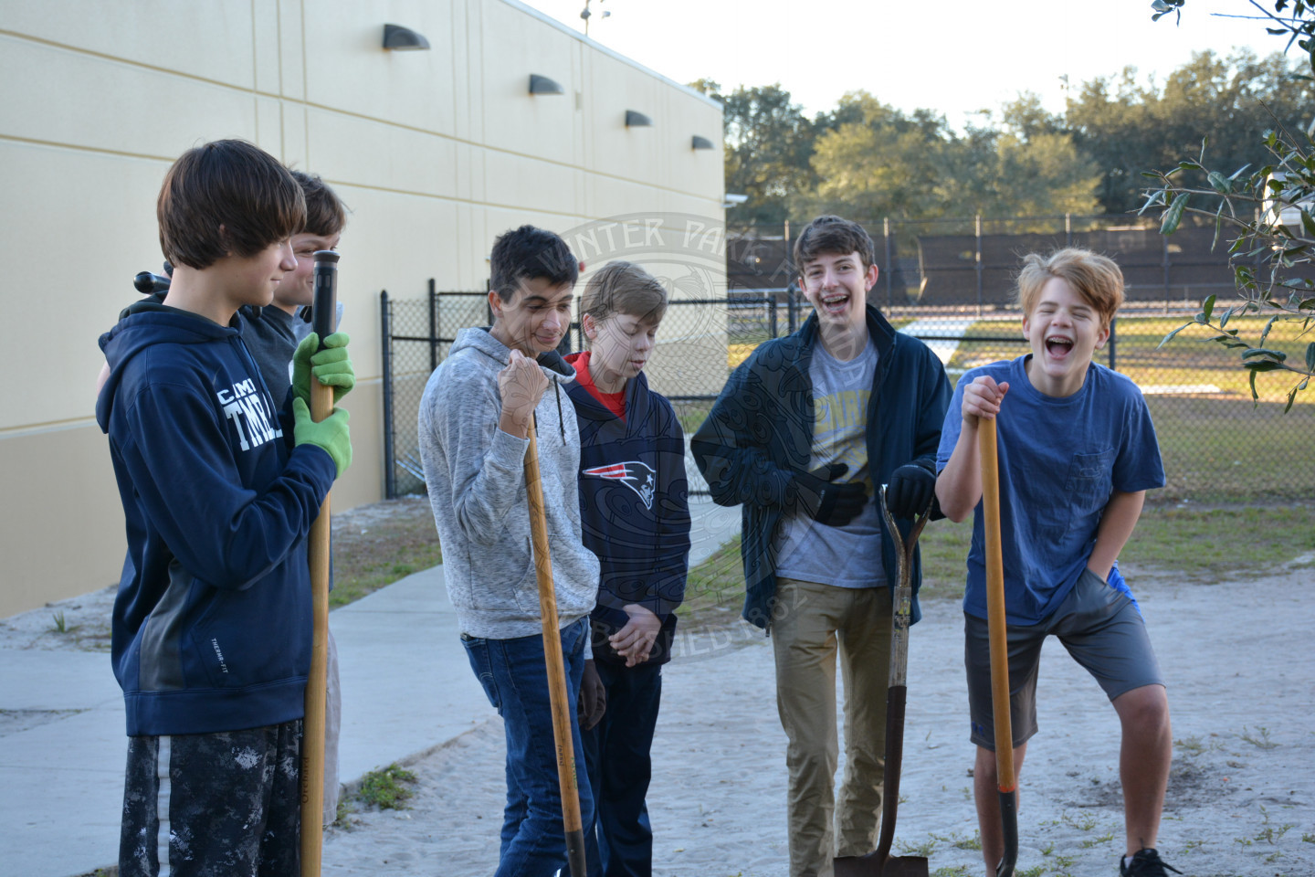 Six students holding shovels laughing