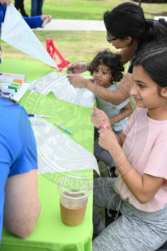 kids drawing on kites to decorate them.