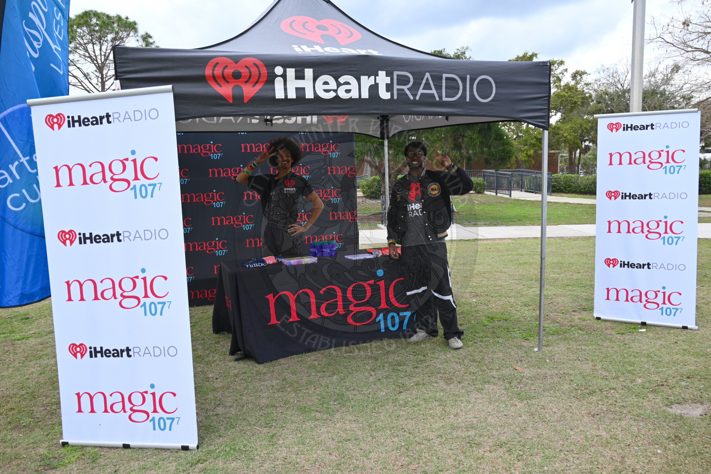 two boys waving standing at the iHeartRadio tent.