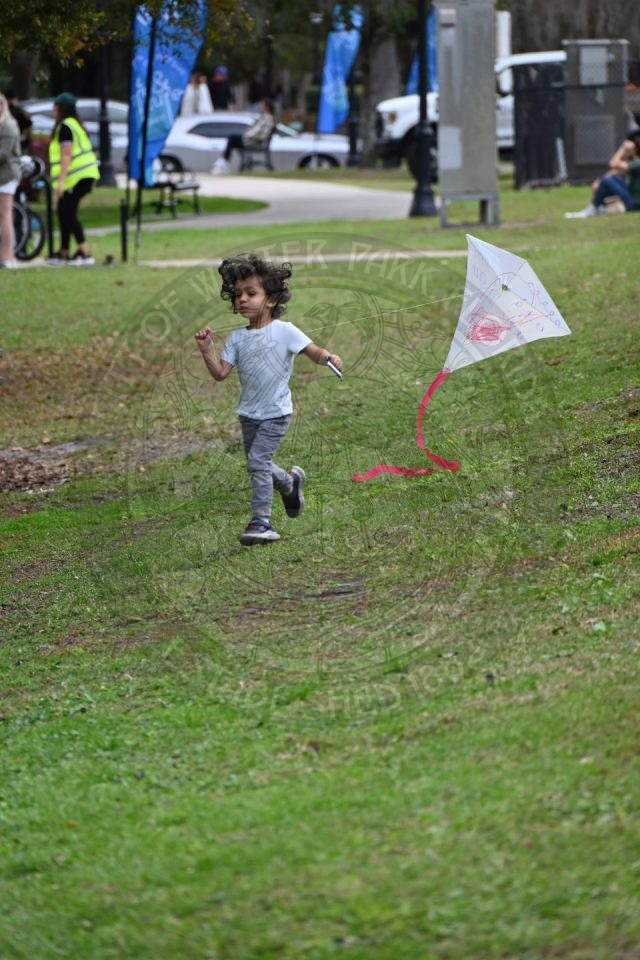 a little boy running and flying his kite.
