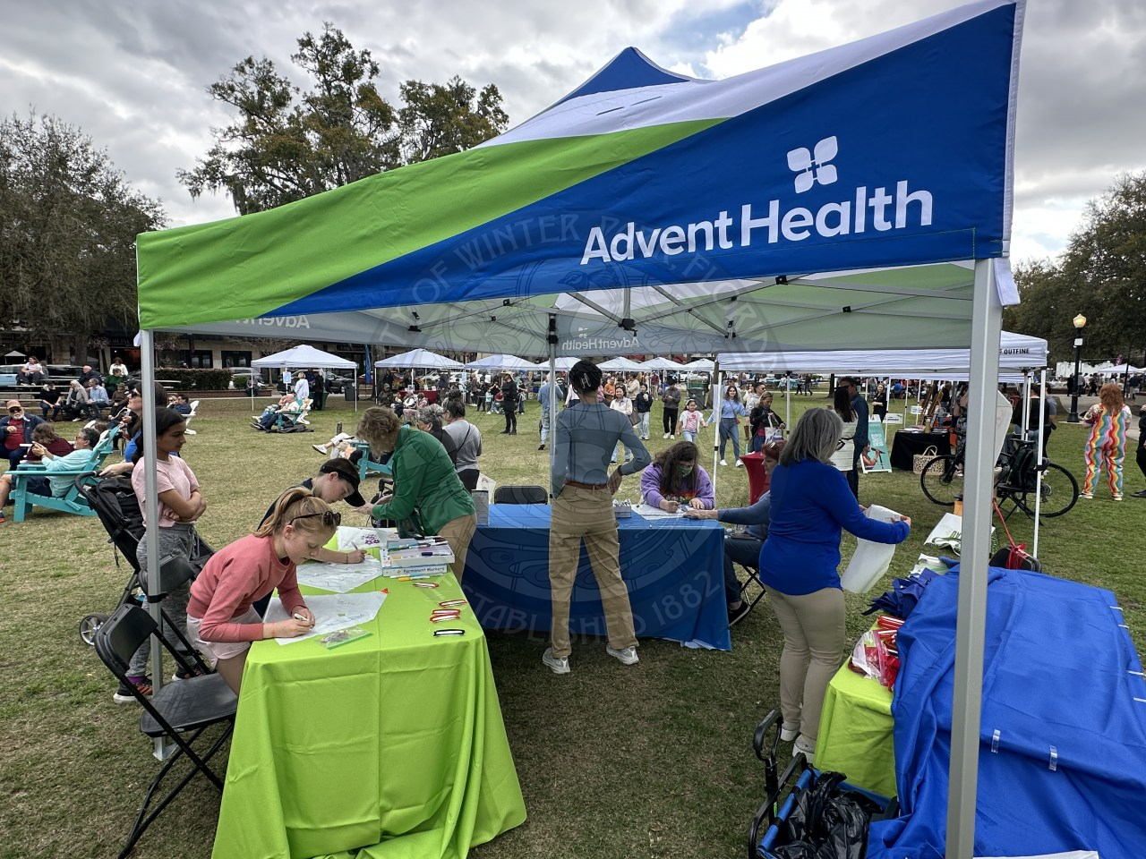 Adventhealth tent with tables set up for kids to decorate kites.