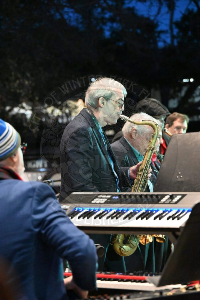 a saxophonist playing his instrument behind a pianist 