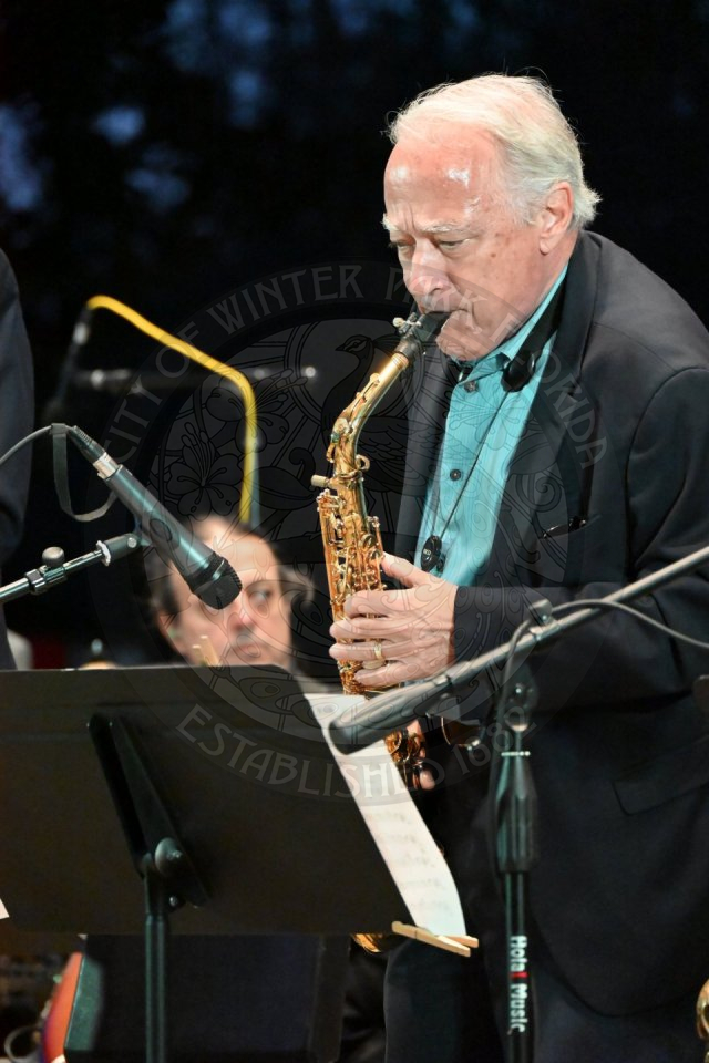 a close up of a saxophonist playing his instrument.