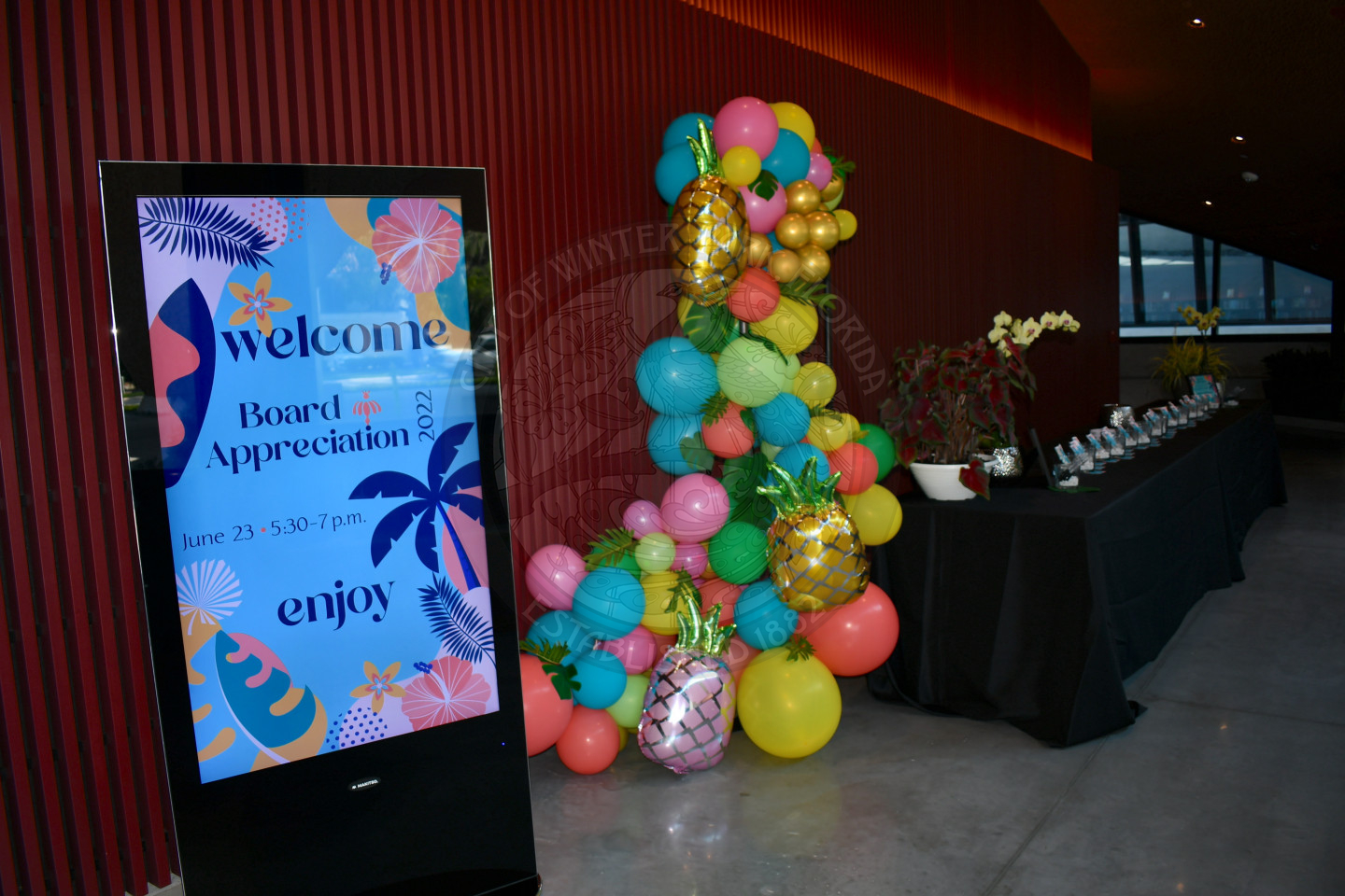 Digital welcome sign with a balloon arch and and welcome table to the right