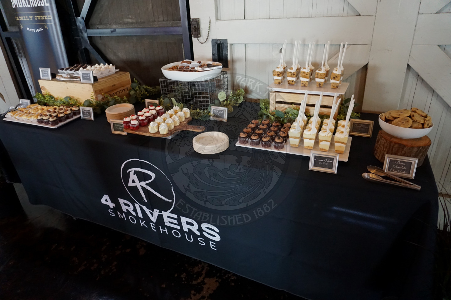 a table set up with a bunch of differents including cake shots, cake balls, cupcakes, cookies, and desset bars.