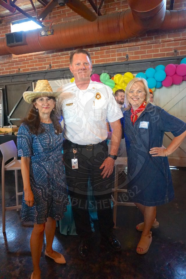 2 woman and 1 men standing next to each other smiling at the camera