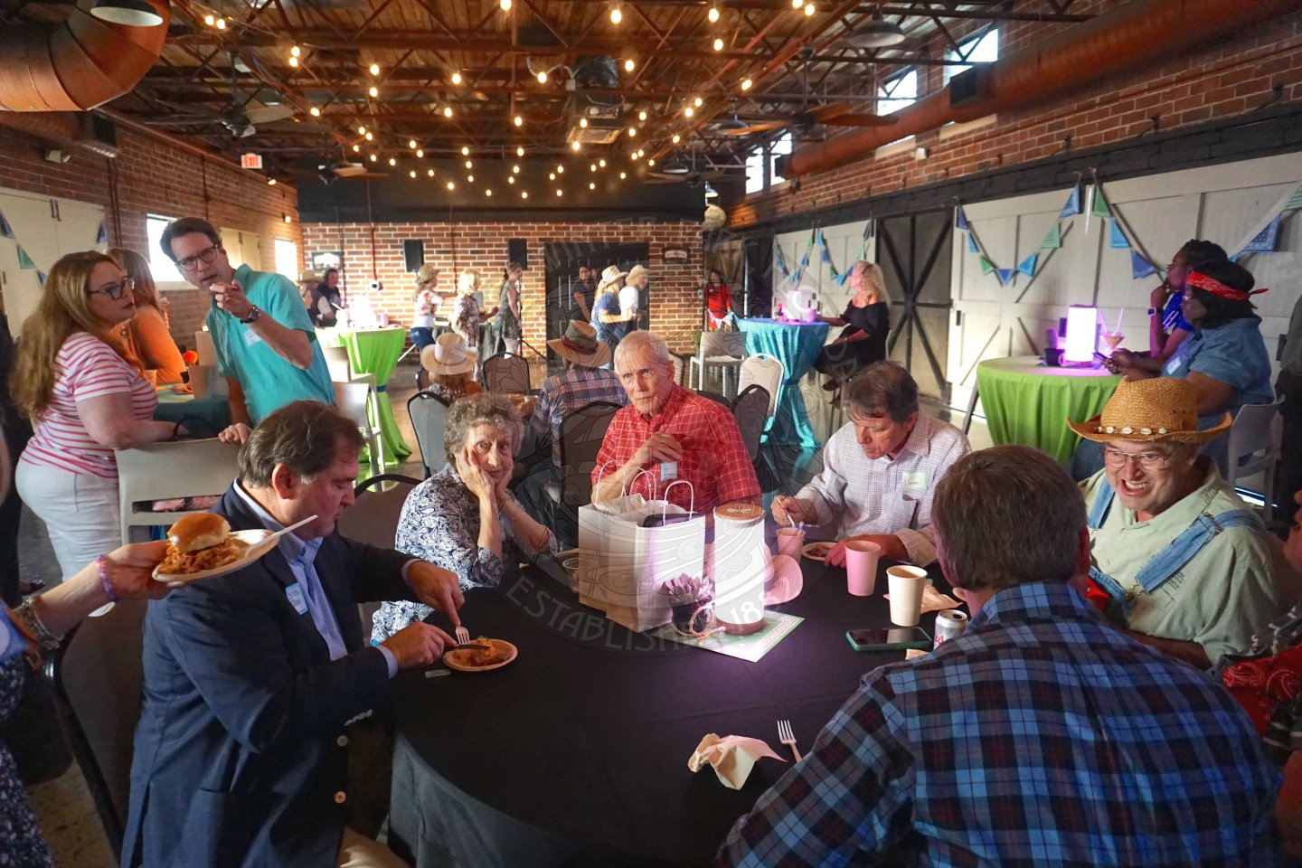 group of people sitting at a table eating and drinking