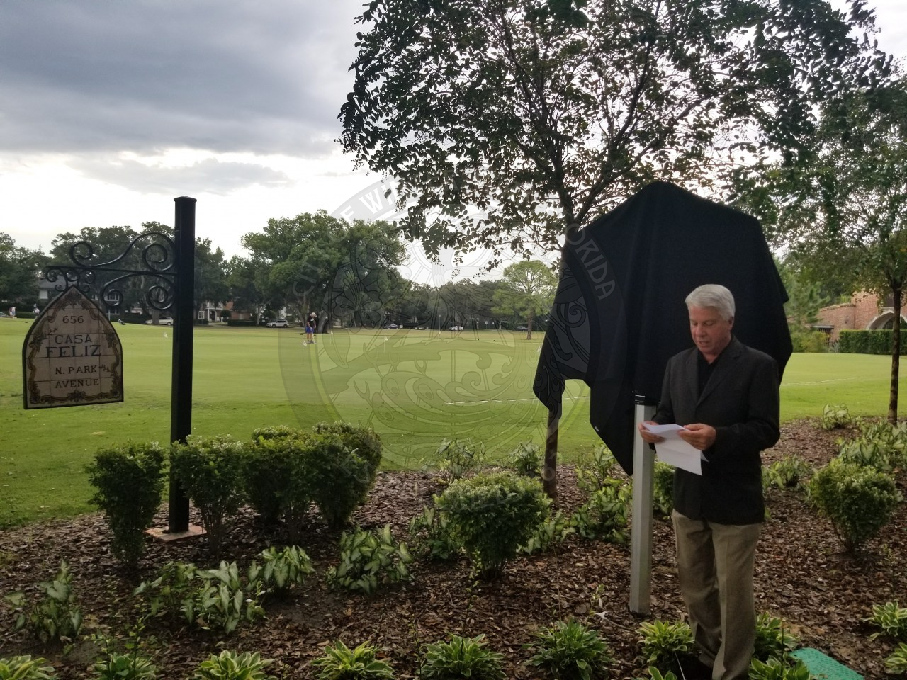 Male speaking to people in the unveiling of historic marker
