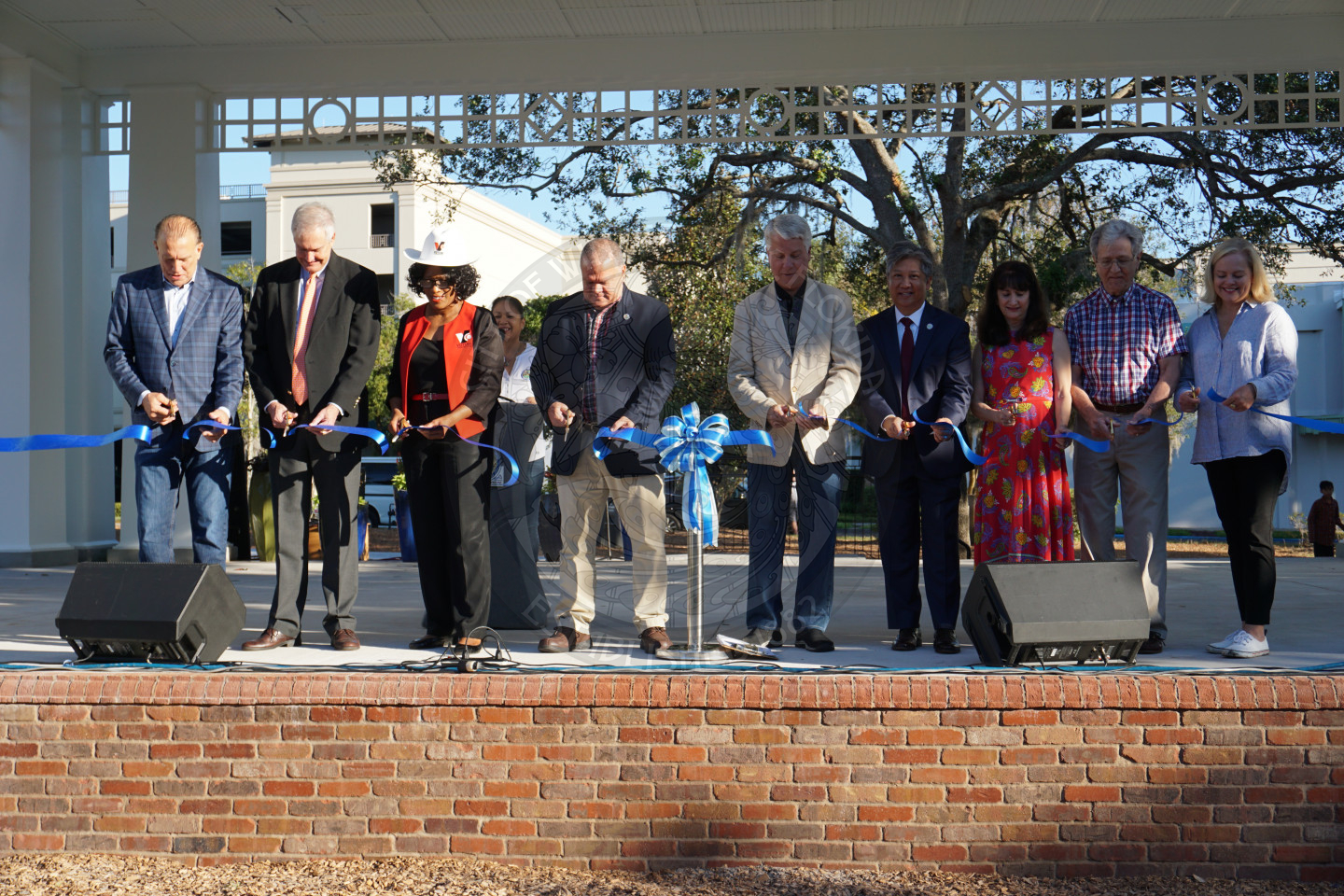 Group of 9 people cutting the ribbon for the new main stage
