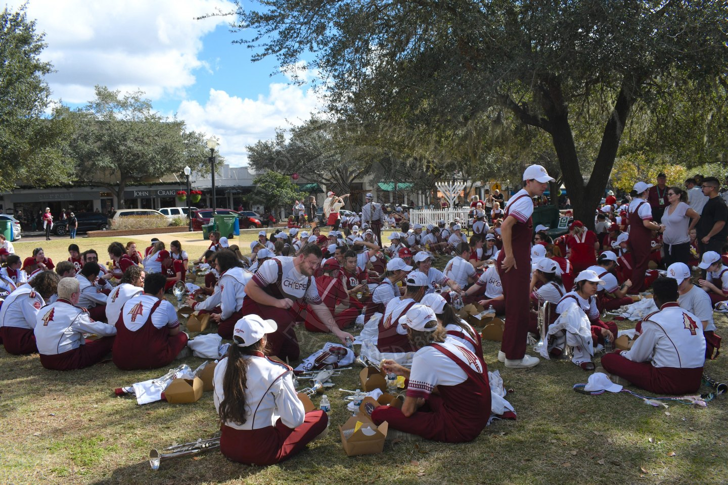 FSU and OU band member sitting in the grass eating lunch after marching and performing