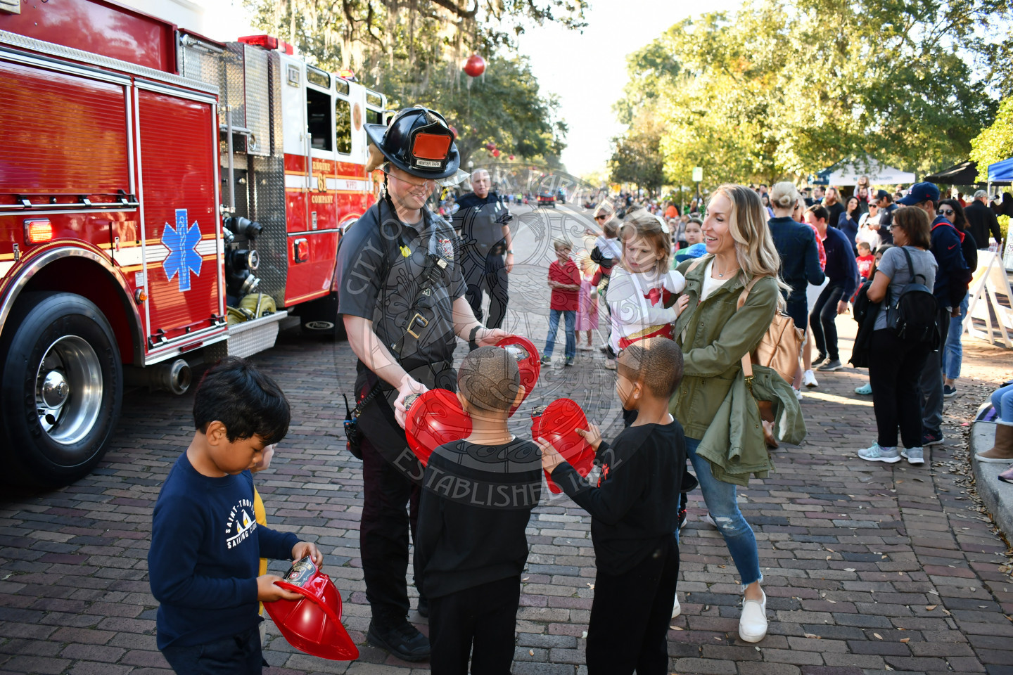 Firefighter handing out helmets to children