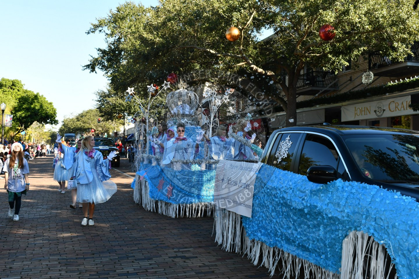 fairies riding in their float waving to the kids in the crowd