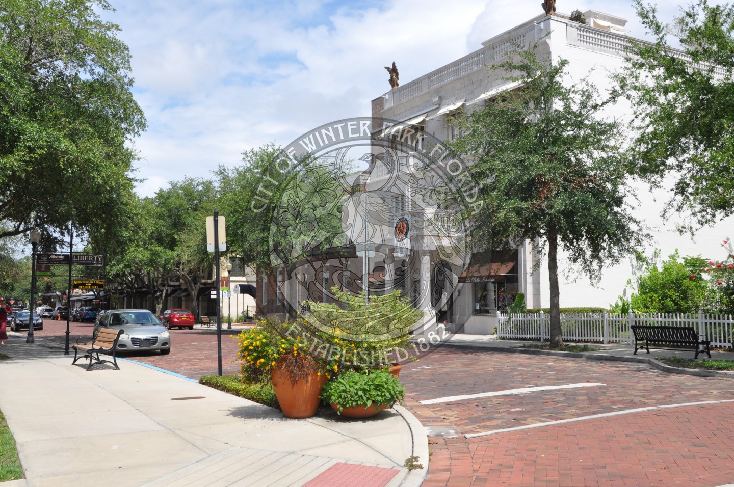 Corner of New England Avenue and Park Avenue showing potted plants and the tree lined street