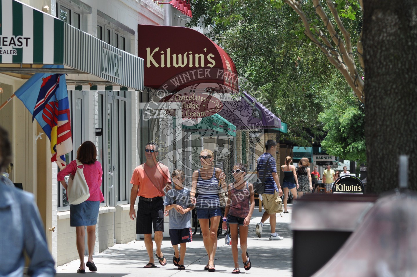 young family walking under the Kilwins canopy down Park Avenue