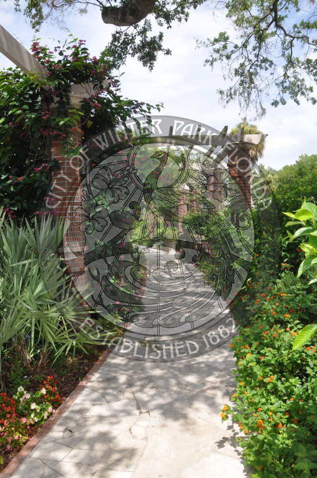 View of the pathway into the Rose Garden with arches and trellis of roses and beautiful landscaping