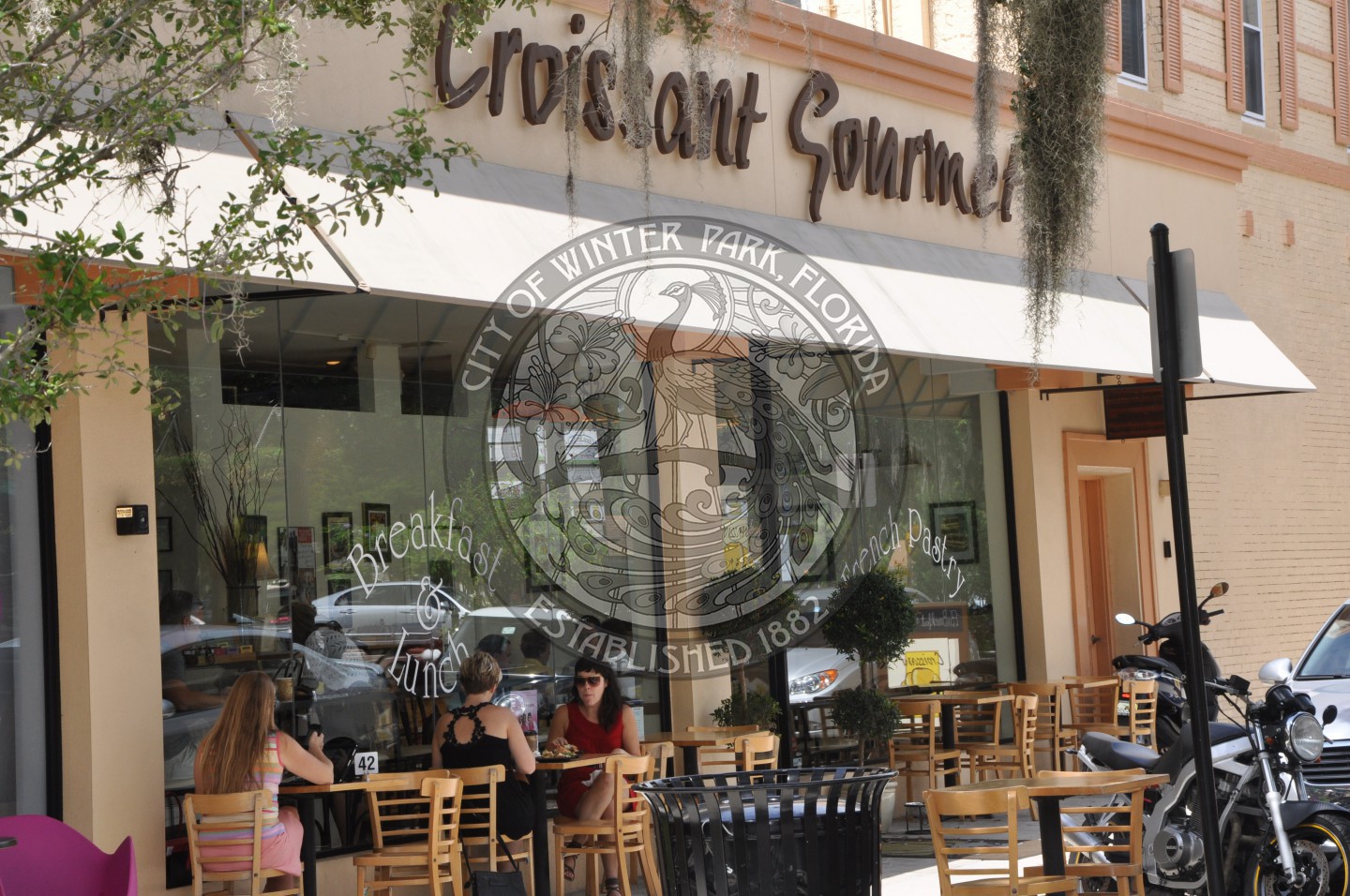 Exterior view of the Croissant Gourmet restaurant with outdoor diners