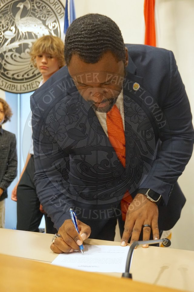 Commisisoner Russell signing the official oath of office paper.