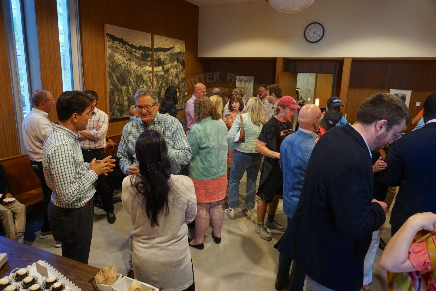 overview of the a room filled with people gathering and celerbating Commissioner Russell.