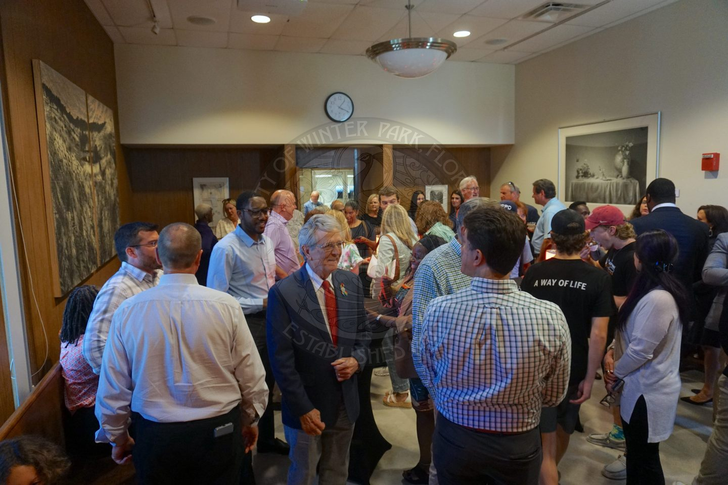 overview of the a room filled with people gathering and celerbating Commissioner Russell.