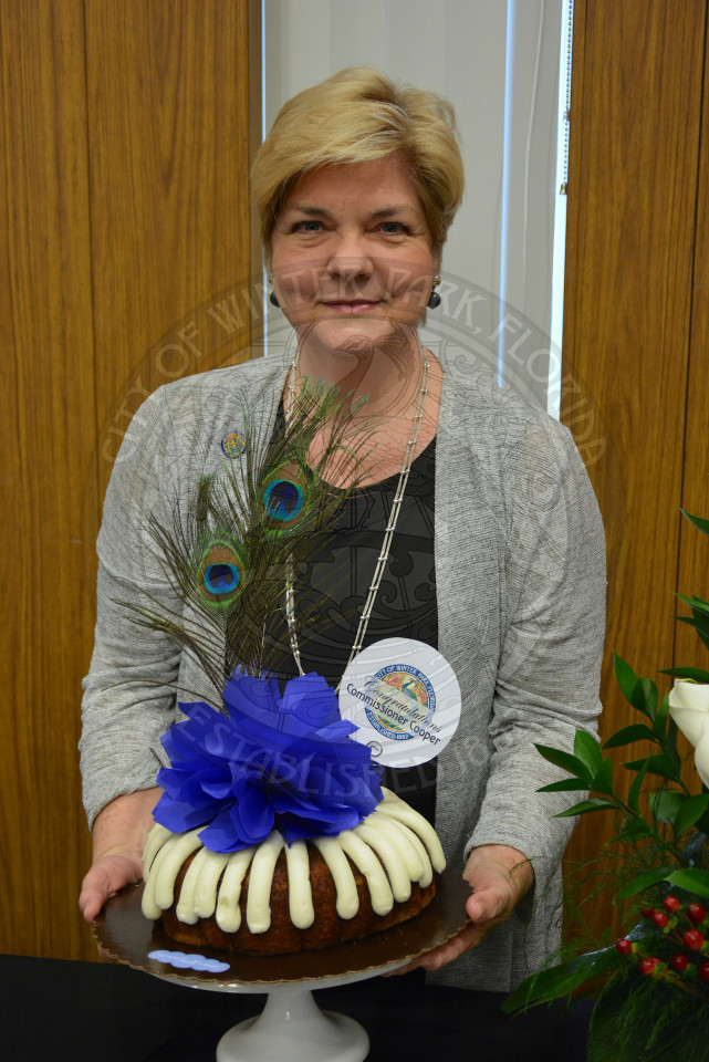 Commissioner Carolyn Cooper poses behind personalized congratulatory cake