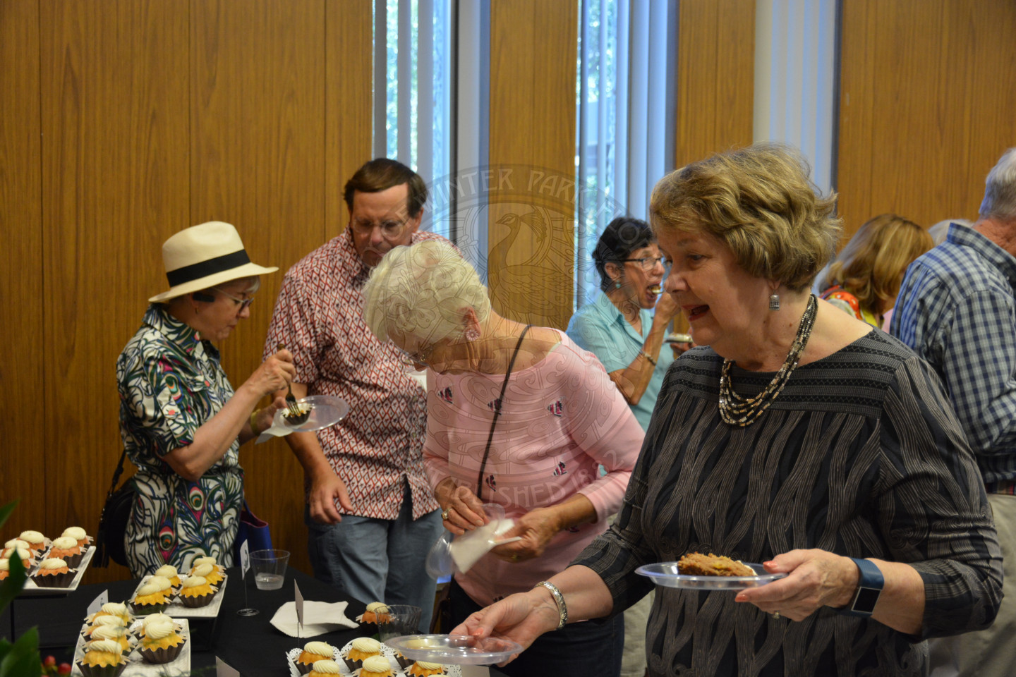 Event attendees at cake table enjoying the various flavors