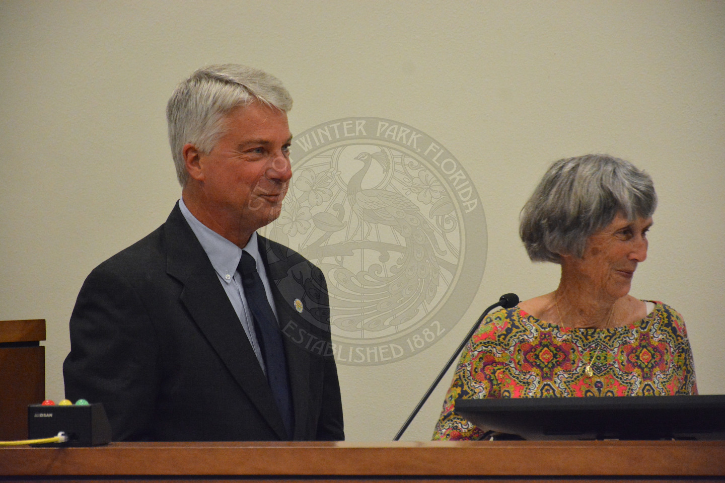 Commissioner Todd Weaver stands at podium as he recites his Oath of Office. given by a female in a floral blouse.