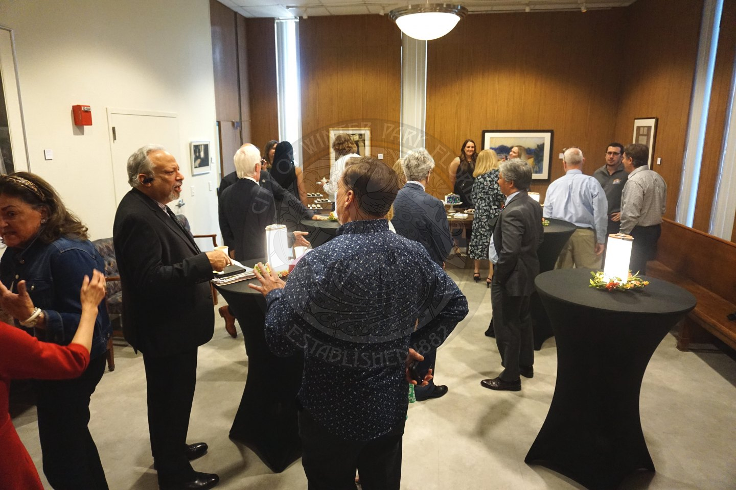 group of people mingling around high-top tables